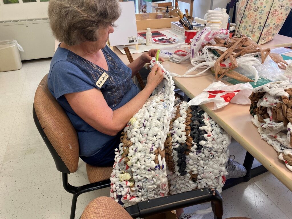 Resident Nan Allen uses a crochet hook to make a mat.